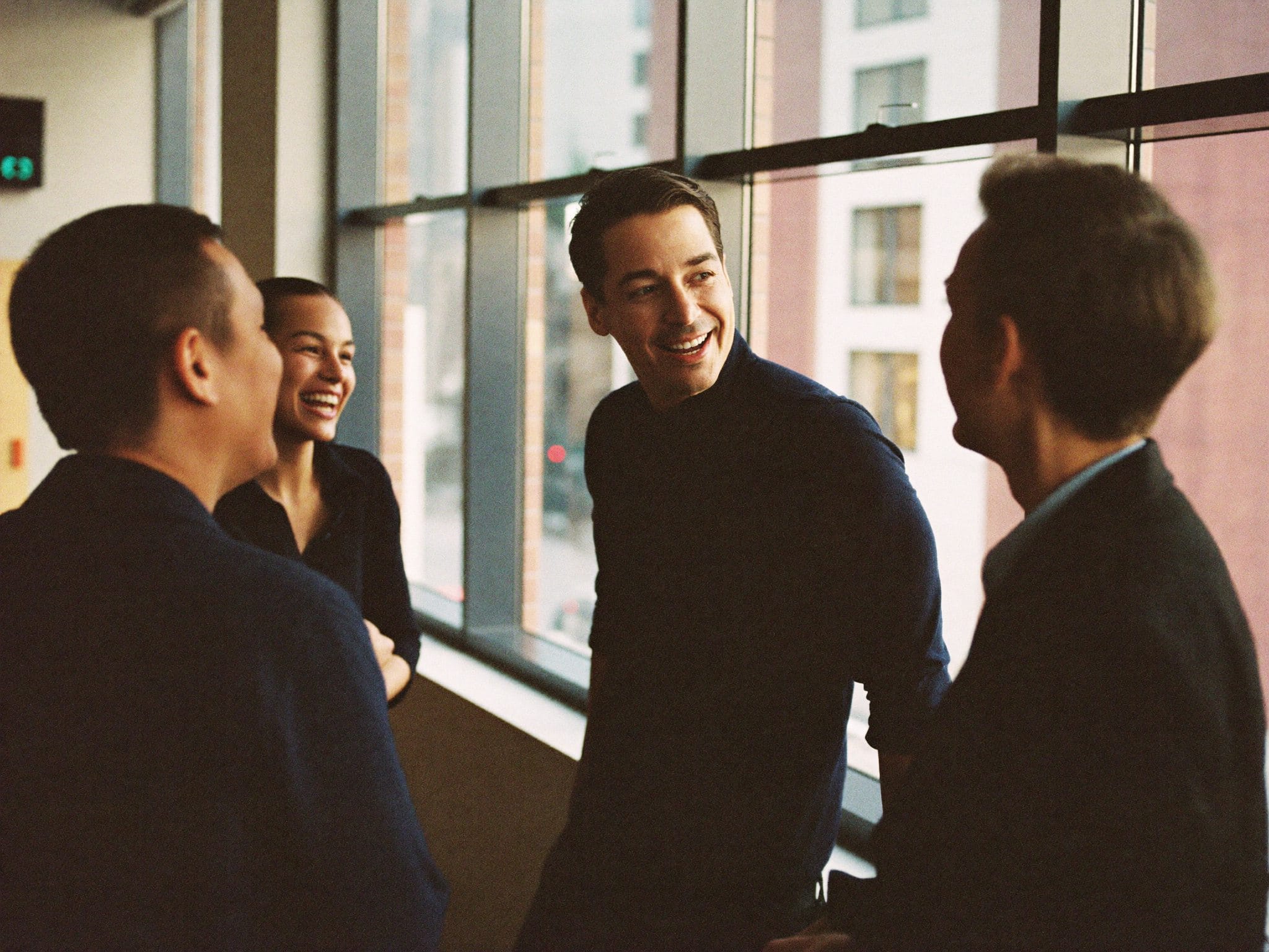 Fotografía de equipo para empresas: grupo de trabajo conversando con luz natural, employer branding